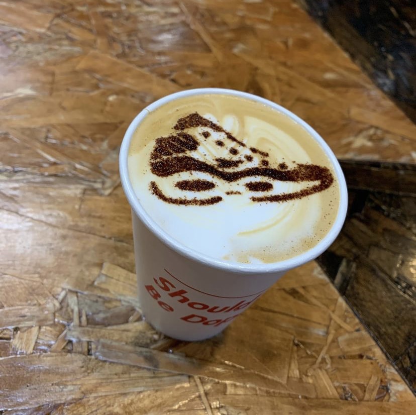 Cup of coffee with a sneaker drawn into the foam
