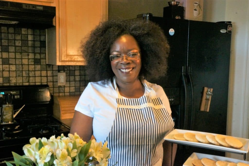 Miss Peabody holding a tray of tea cakes.