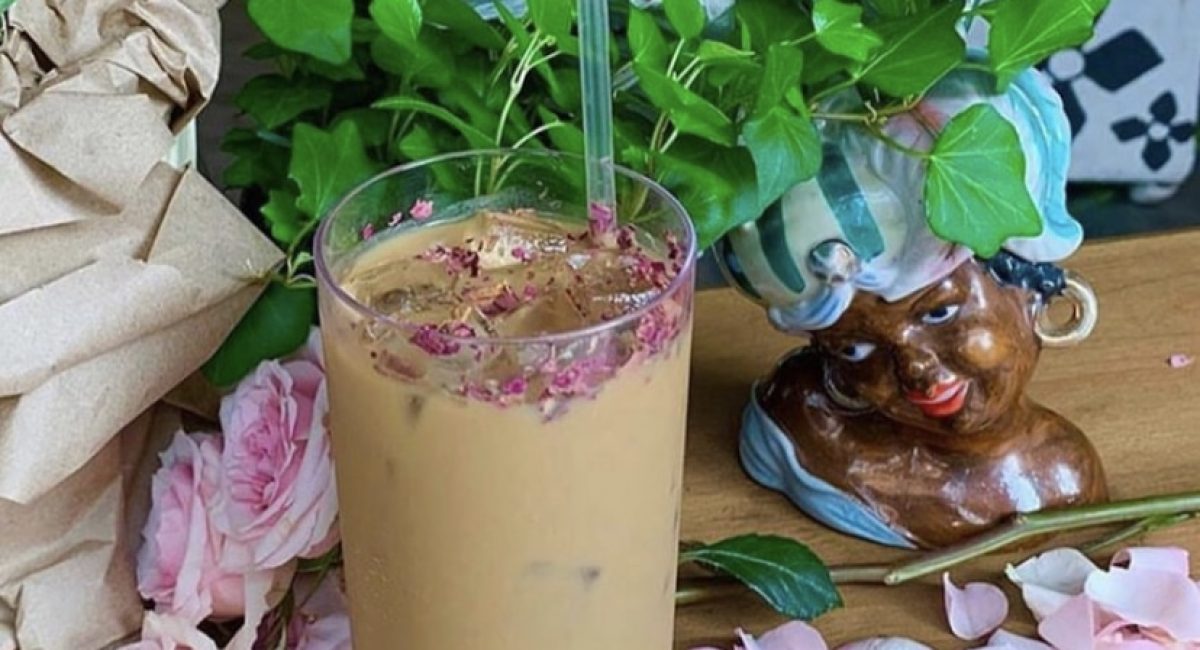 Rose petals surrounding a cup of cold brew